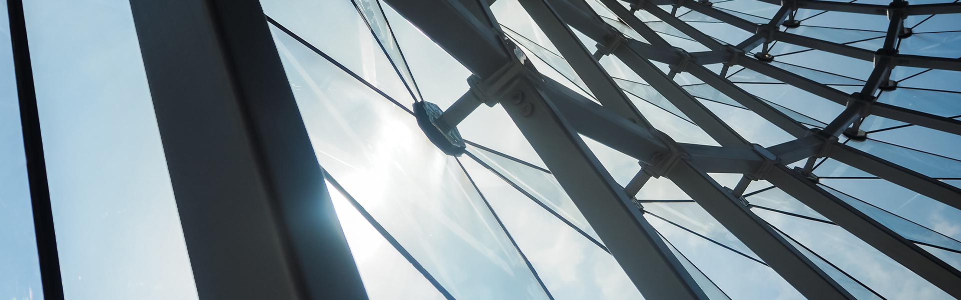 Abstract architectural glass structure looking upward representing scale, transparency, and innovation in AI-driven pharma insights