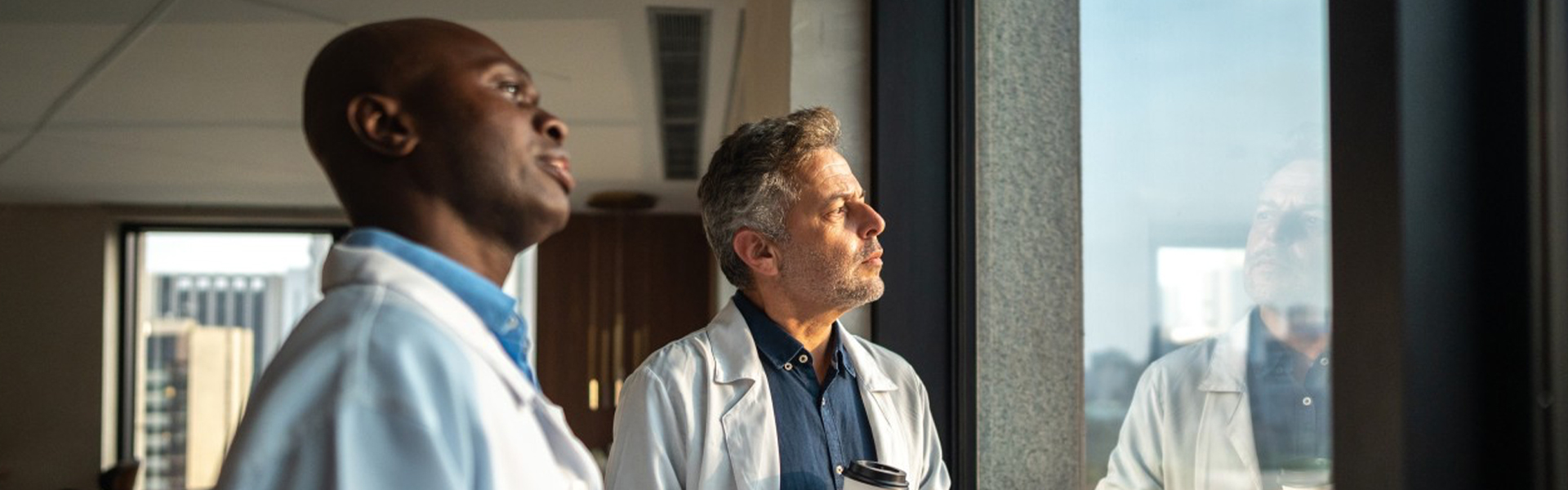 Two physicians in thoughtful reflection representing the human identity and decision-making complexity behind HCP prescribing behavior in pharma research