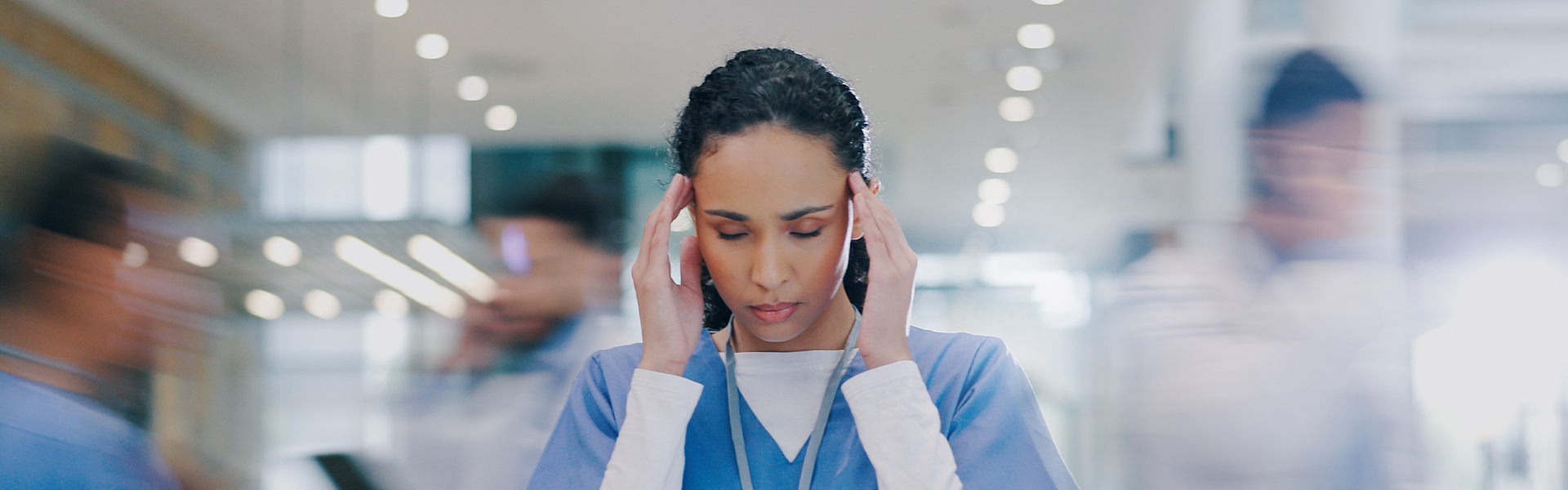 Nurse under pressure in a busy hospital corridor representing the growing divide between independent and institutional healthcare settings and its impact on physician practice