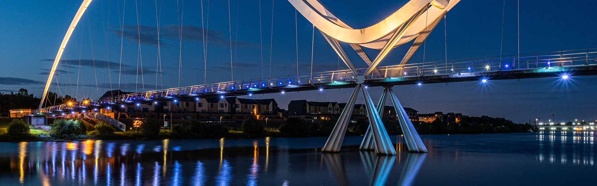Illuminated bridge spanning a river at night representing the gap between insight and action in pharma market research strategy