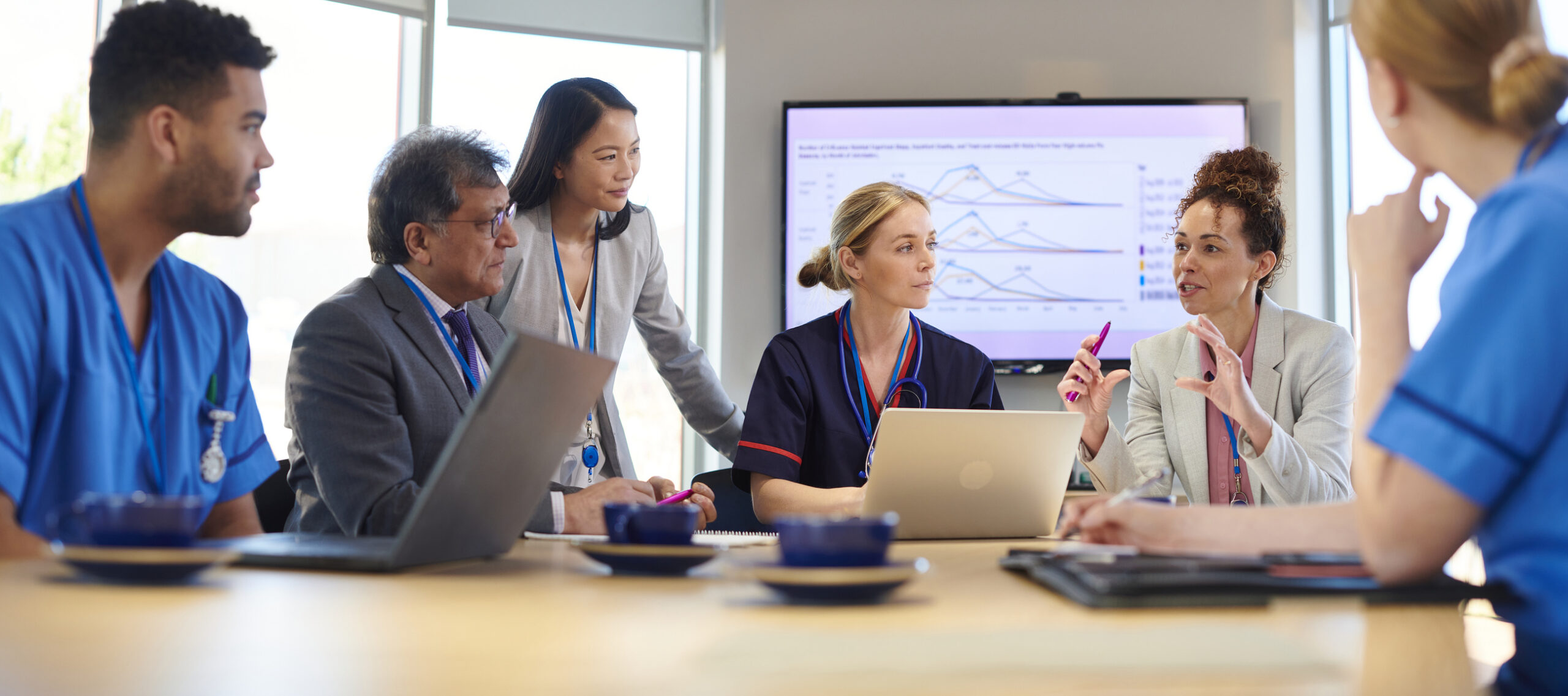 Cross-functional healthcare team reviewing data and portfolio strategy together in a meeting